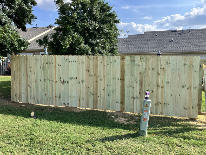 A newly installed wood privacy fence in a residential backyard by Rice&Family Fencing LLC in Greenfield, TN.
