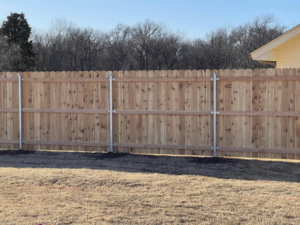 A newly installed wood privacy fence with sturdy metal posts by Fence Restorations LLC in Ponca City, OK.