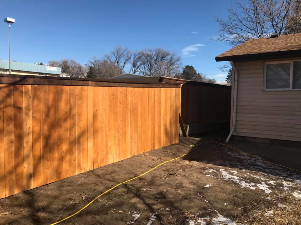 A new wood privacy fence installed next to a residential house by Red Dirt Fencing and Woodwork, LLC in Fountain, CO.