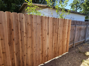 A new wood privacy fence standing next to an older, weathered fence, demonstrating a recent upgrade by Regan Fencing & Services in Nampa, ID.