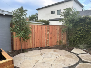 A new wood privacy fence installed behind a stone patio by Don Peterson Wood Fences & Decks in Santa Monica, CA.