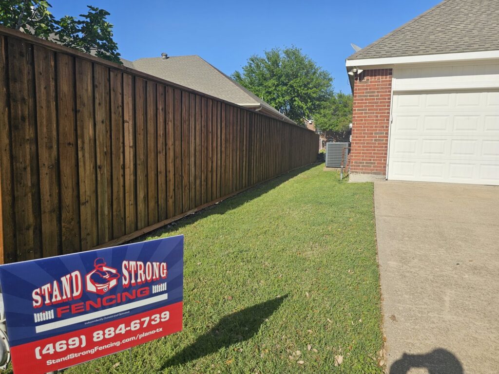 A newly installed wood privacy fence in a residential backyard by Stand Strong Fencing of Plano, TX