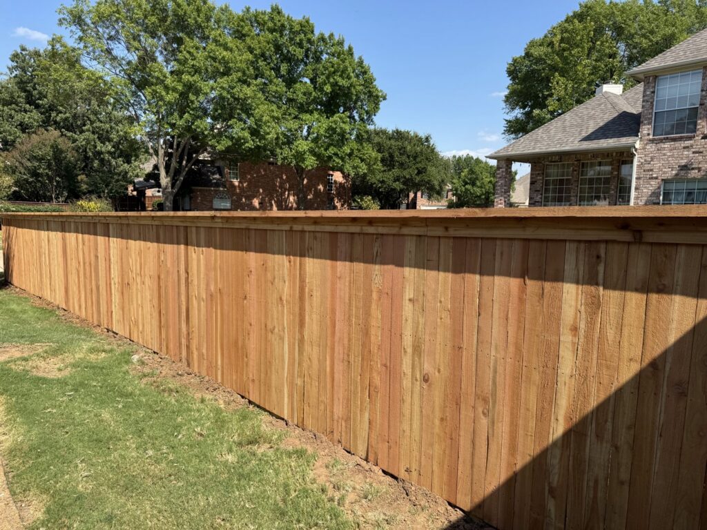 A newly installed wood privacy fence in a residential backyard by Dallas Fence in Dallas, TX.