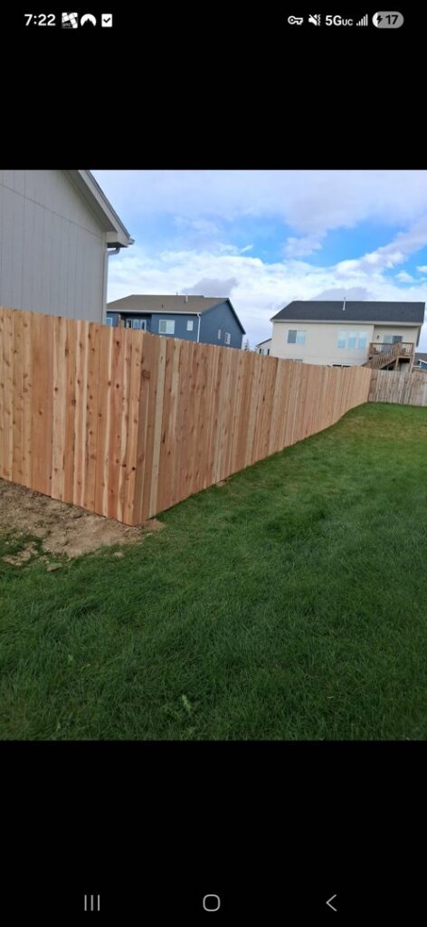 A newly installed wood privacy fence in a residential setting by Fencing Company Of Omaha in Omaha, NE.
