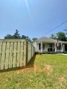 A newly installed wood privacy fence alongside a residential home, a project by TC Fencing LLC in Tuscaloosa, AL.