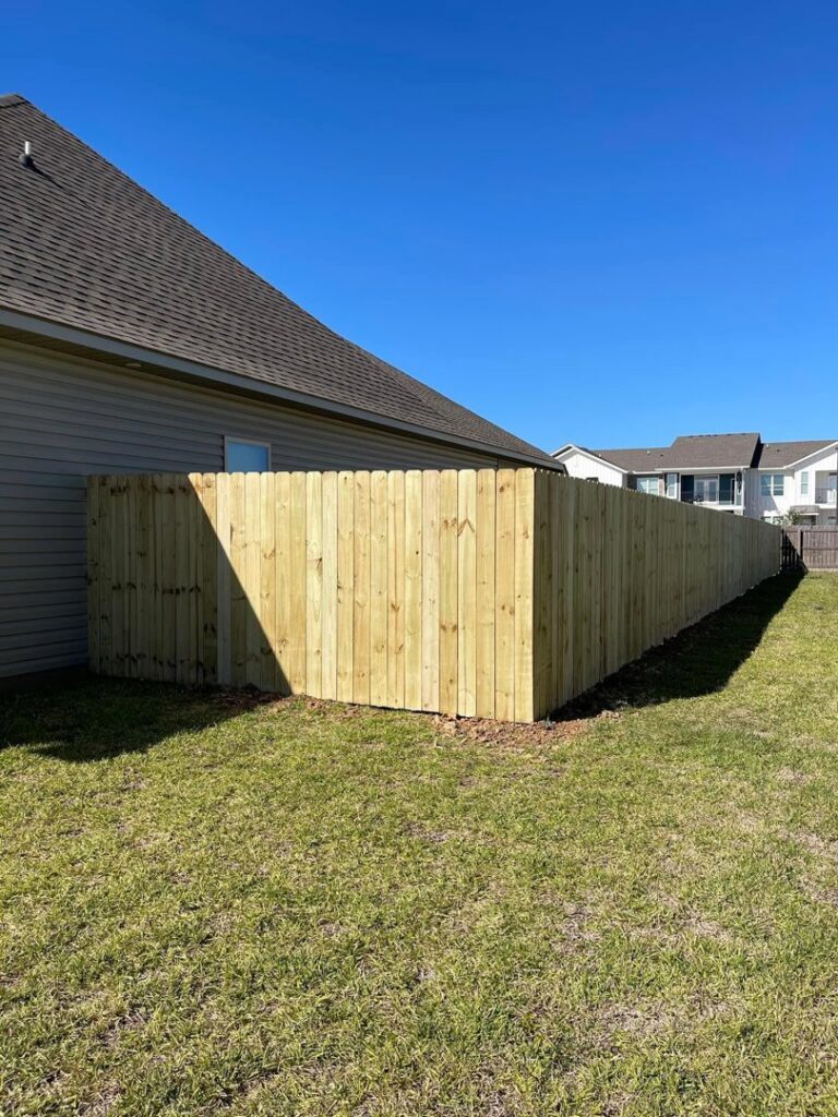 A newly installed wooden privacy fence enclosing a residential backyard by JH Fencing in Lawrence, KS.