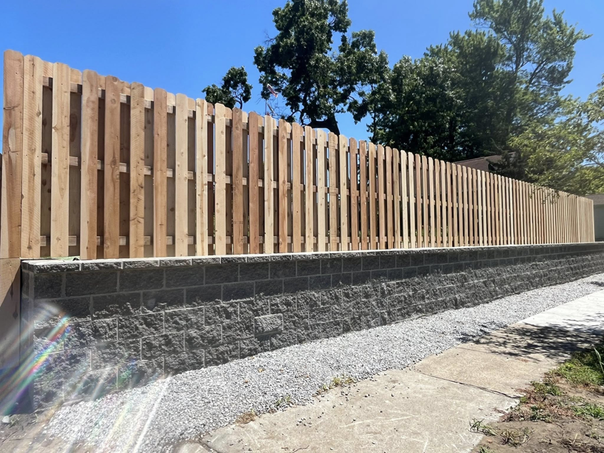 A newly installed wood privacy fence on a retaining wall by Final Touch Fencing LLC in Macomb Township, MI.
