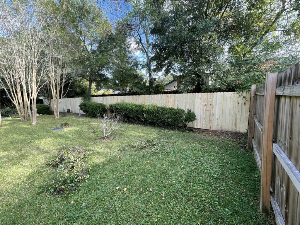A new section of wooden privacy fence installed alongside an existing fence by Jaguar Fence LLC in Mobile, AL.