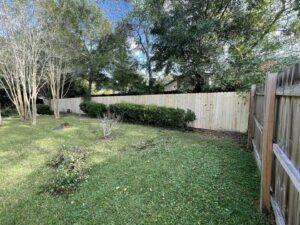 A new section of wooden privacy fence installed alongside an existing fence by Jaguar Fence LLC in Mobile, AL.