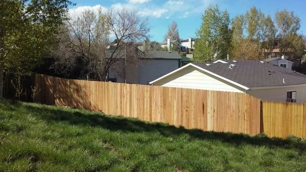 A newly installed wood privacy fence on a sloped residential property by Done Wright Fencing and Welding in Denver, CO.