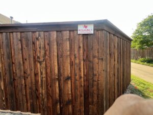 A detailed view of a newly installed wooden privacy fence with a gate, showcasing craftsmanship by Reliable Texas Fencing in Fort Worth, TX.