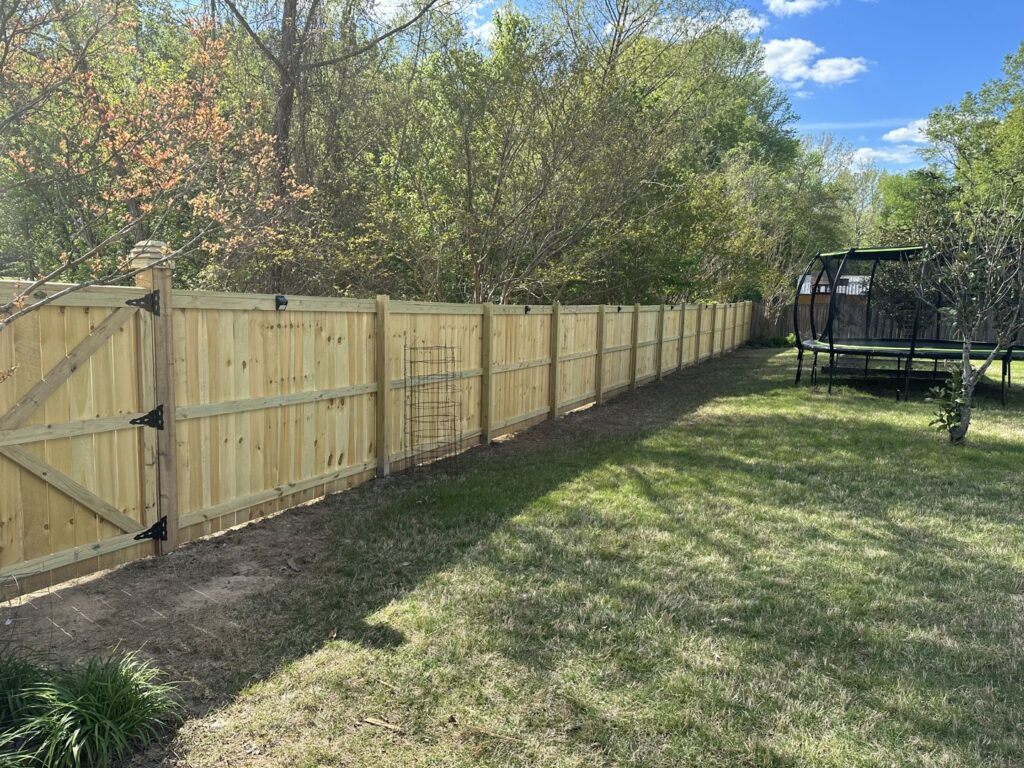 A newly installed wood privacy fence with a matching gate by Fences & Landscape Inc in Little Rock, AR.