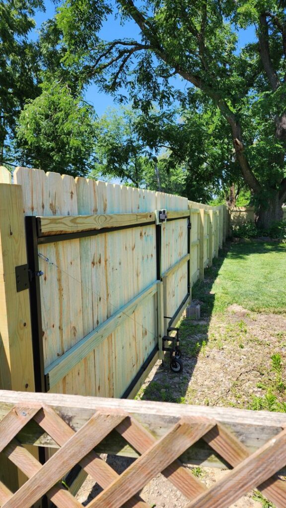 A newly installed wood privacy fence with a sturdy gate, built by Hotshot Fencing and Gates in Kansas City, MO.