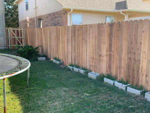 A newly installed wood privacy fence and gate in a backyard by Pick-It Fences LLC in Pflugerville, TX.