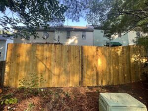 A newly installed wood privacy fence with a gate in a backyard by RDU Fence in Holly Springs, NC.