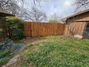 A newly installed wood privacy fence with a gate by Straight Shot Solutions, LLC in Fort Worth, TX.