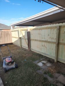 A newly installed wood privacy fence with a gate in a residential backyard by The Fence Dudes in Birmingham, AL.