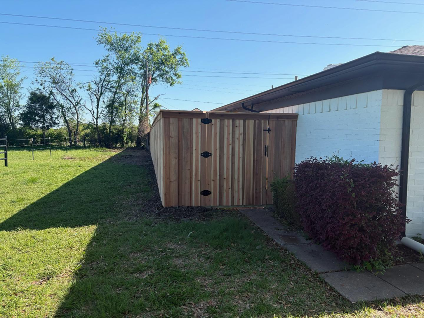 A newly installed wooden privacy fence with two gates next to a house by True Ways Services LLC in Mesquite, TX.
