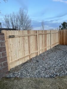 A newly installed wooden privacy fence featuring a Mule Fence Inc. sign in Sparks, NV.