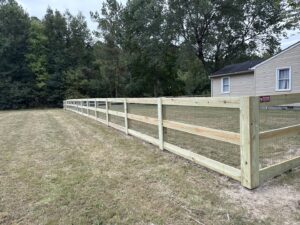 A newly installed wood split-rail fence with wire mesh extending across a property by Superior Fence & Rail Richmond, VA.