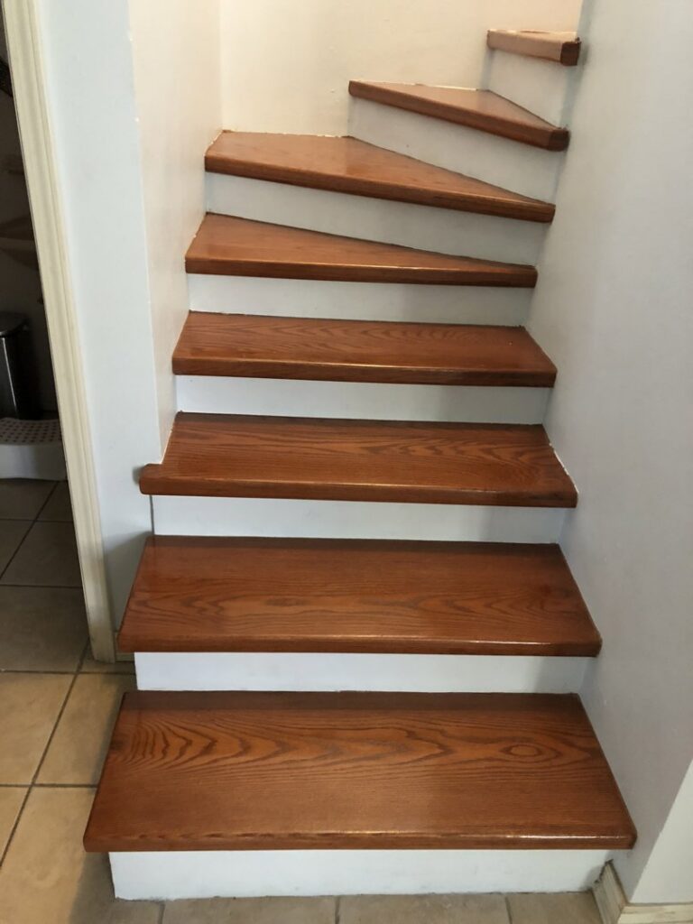 Freshly installed wood stair treads with white risers by Carpets Texas in El Paso, TX.