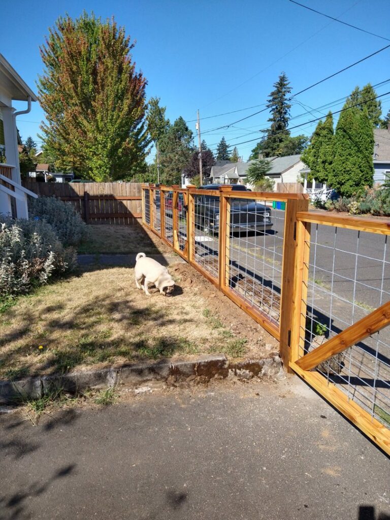 A newly installed wood and wire mesh fence line at a residential property by Howell Fence Inc. in Oregon City, OR.