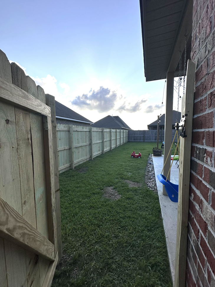 View looking down a newly installed wooden backyard fence line from an open gate by Gator Fence Co. in Miami, FL