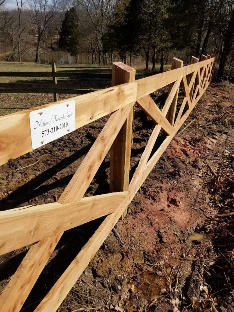 Newly installed wooden fence with a National Fence & Gate business sign in Ironton, MO.