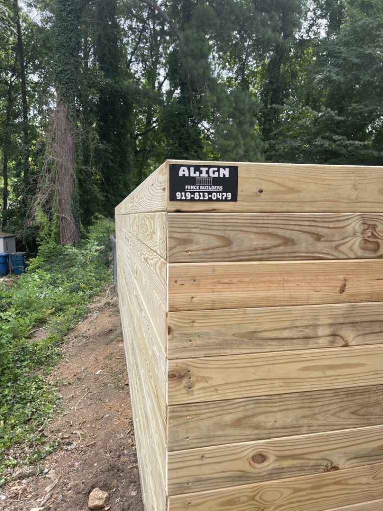 A newly installed wooden fence with the Align Fence Builders business sticker visible in Durham, NC.