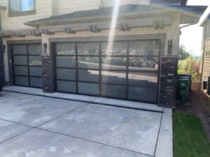 A newly installed wooden-look garage door on a house under construction by CHS Garage Repair of Seattle, WA.