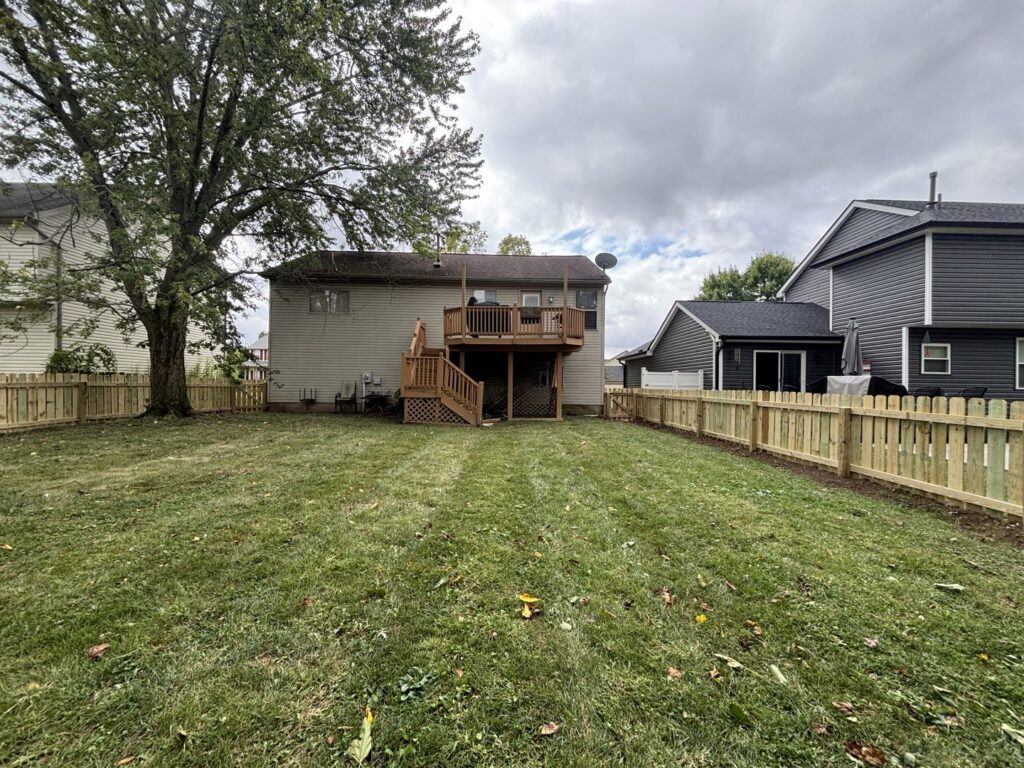 A newly installed wooden picket fence surrounding a residential backyard by D&M Renovation Services LLC in Columbus, OH.