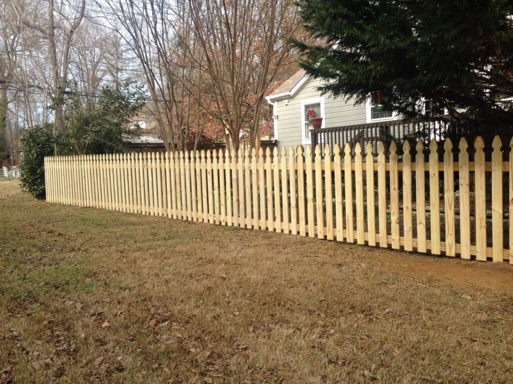 A newly installed wooden picket fence in a residential yard by Timber Fencing in Charlotte, NC.