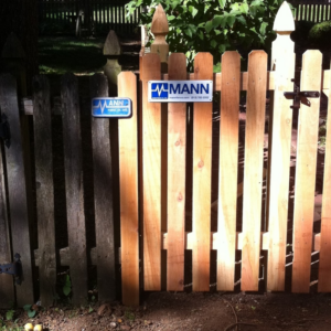 A newly installed wooden picket fence section by Mann Fence Co., Inc. in Olathe, KS.