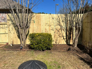 A newly installed wooden privacy fence in a residential backyard by Allen Fences & Decks, LLC in Tuscaloosa, AL.