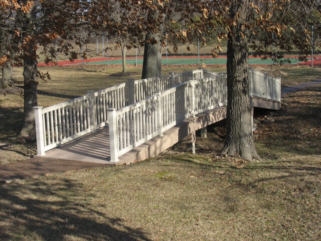 A newly installed natural wood privacy fence in a residential setting, built by Custom Design Fence & Deck, Inc. in Ofallon, MO