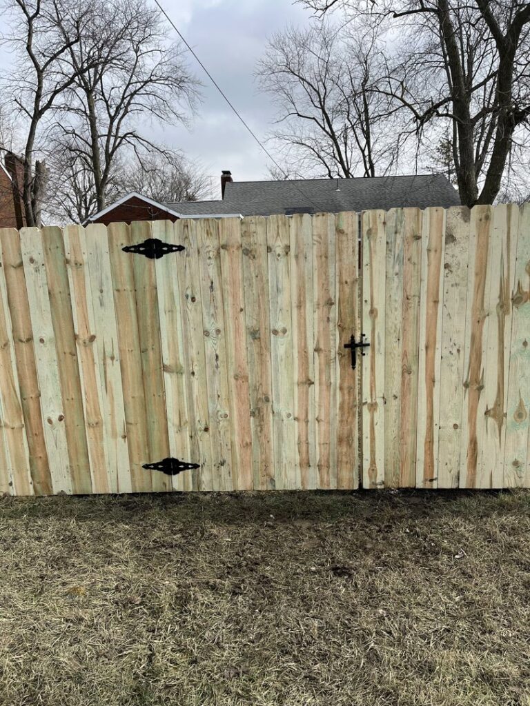 A newly installed wooden privacy fence with a matching gate by Affordable Fence Builders in Dayton, OH.
