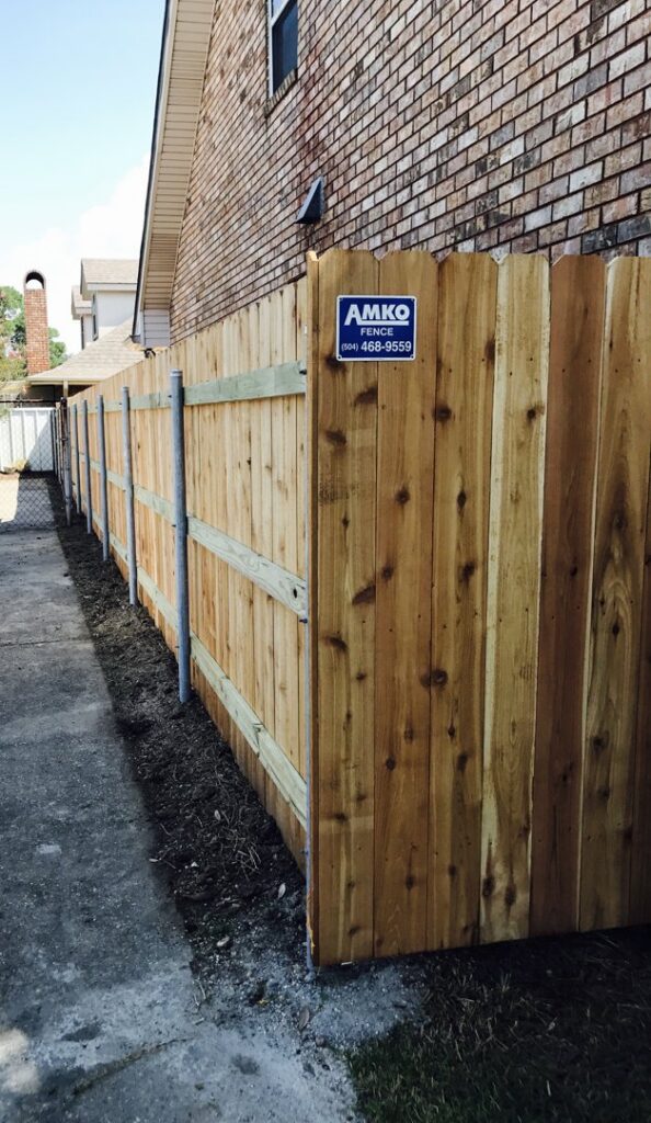 A new wooden privacy fence with metal posts installed by Amko Fence Co. in Kenner, LA.