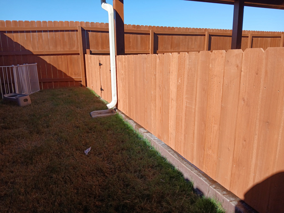 A newly installed wooden privacy fence in a backyard by Olson Handyman Services, LLC in New Braunfels, TX