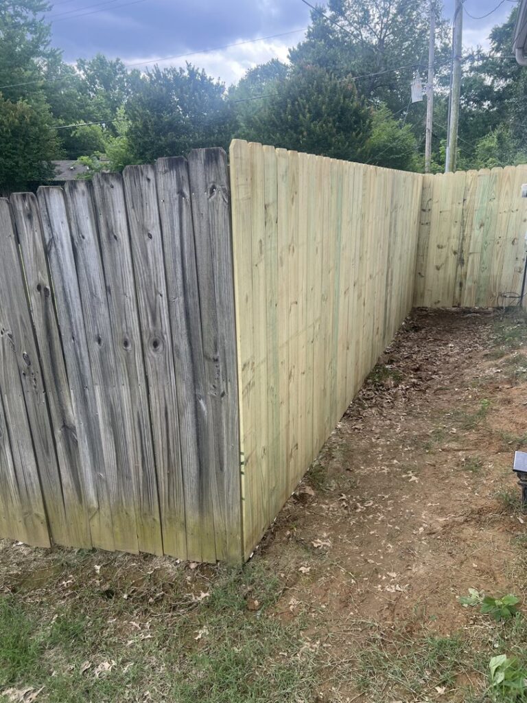 A new wooden privacy fence installed next to an older fence, demonstrating replacement work by First Responder Outdoor Construction LLC in Bartlett, TN.