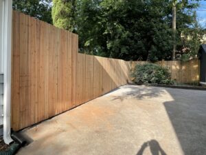 A newly installed wooden privacy fence along a residential property line by Gates Contractors in White, GA.