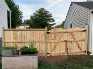 A new wooden privacy fence with a sturdy double gate, expertly installed by Arias Fence & Repair in Manassas, VA.