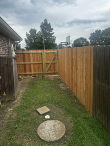 A newly installed wooden privacy fence with a gate next to an existing fence by J&L Fence in Zolfo Springs, FL.