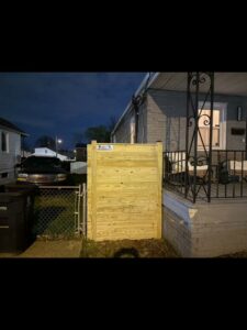 A newly installed wooden privacy gate next to a residential home, completed by AFK FENCE LLC in Waldorf, MD.