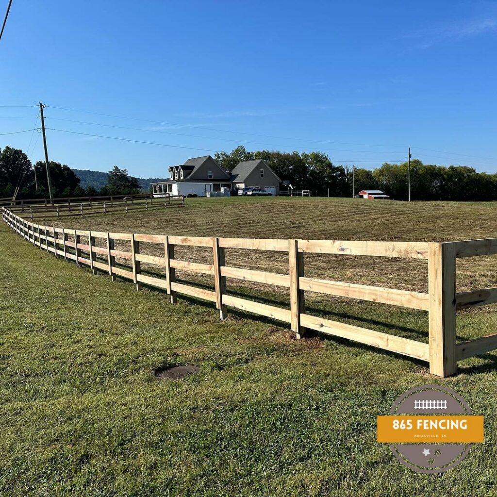 A long, newly installed wooden split-rail fence running through a green field, built by 865 Fencing in Knoxville, TN.