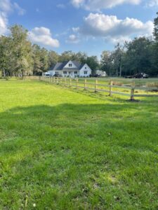 A newly installed wooden split-rail fence extending across a large property by Stono Fencing & Exteriors in Johns Island, SC