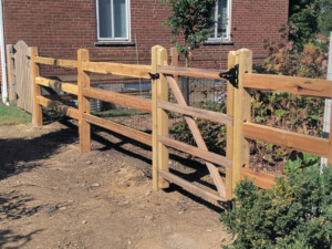 New wooden split-rail fence with wire mesh and a gate installed by Wallace Fencing in Cincinnati, OH.