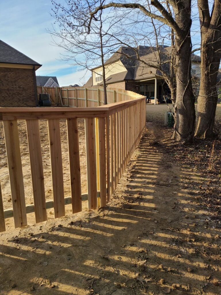 A newly installed wooden vertical slat fence by First Responder Outdoor Construction LLC, providing privacy in Bartlett, TN.