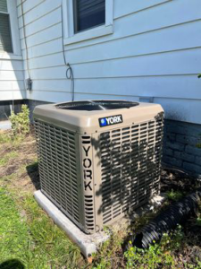 A newly installed York outdoor HVAC unit next to a residential building by SJ Conner and Sons Inc in Roanoke, VA