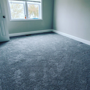 An empty residential room featuring newly installed grey carpet by Yankees Carpet Inc in Baltimore, MD