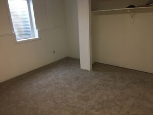 A newly carpeted room with a window and closet, showcasing a completed job by Carpet Connection of Denver in Aurora, CO.